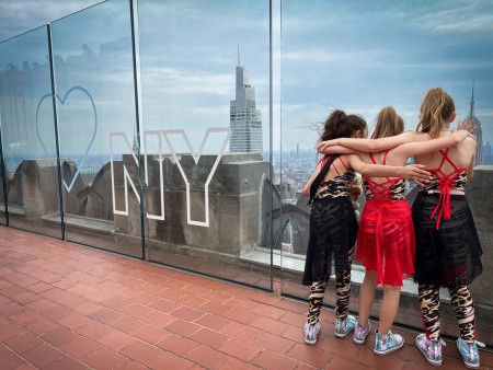 three girls in costume at top of the rock
